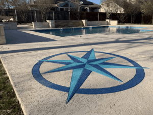 Poolside compass rose design on concrete surface.