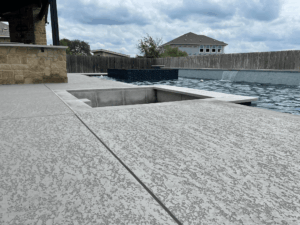 Backyard pool patio with cloudy sky.