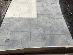 Gray tiled walkway with shadows and sunlight