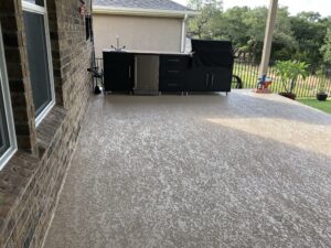 Outdoor kitchen on patio with grill and sink.