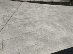 Gray concrete paver patio with geometric pattern.