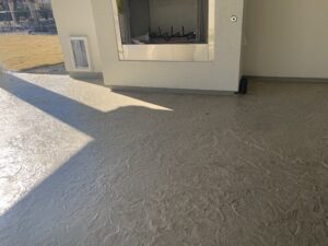 Textured concrete floor in sunlit patio area.