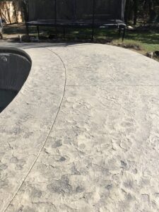 Concrete pool deck with surrounding green grass