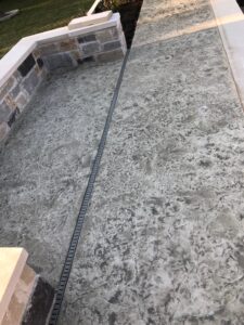 Textured concrete path with stone walls.