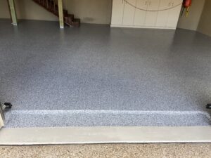 Epoxy-coated garage floor with stairs in background.