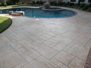 Backyard pool with stone patio and landscaping.