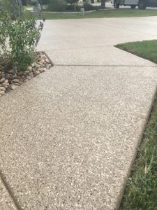 Concrete driveway with grass and pebbles border