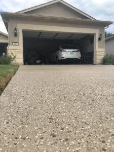 Open garage with parked white car