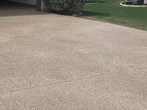 Concrete driveway with adjacent green lawn