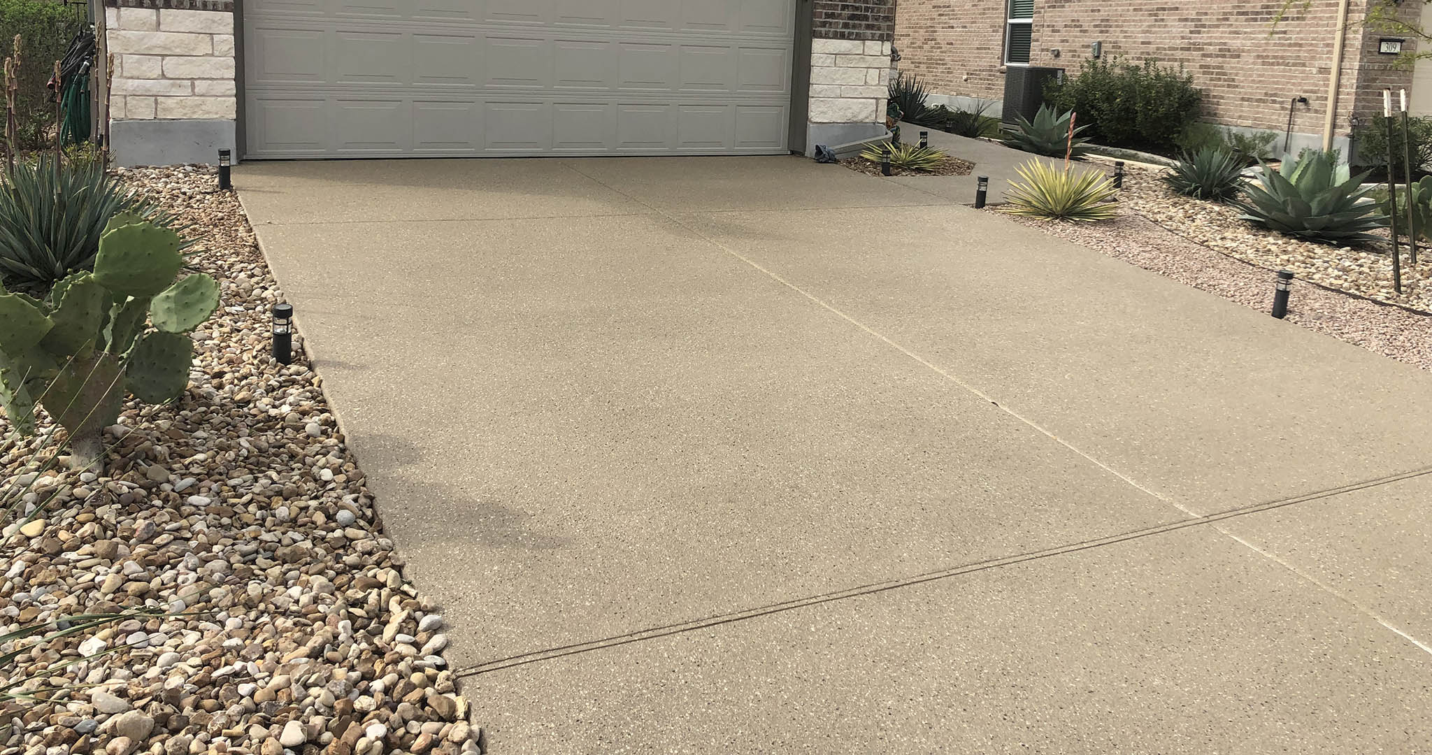 Photo-Jun-05-12-50-47-PM Concrete driveway with desert landscaping and succulents
