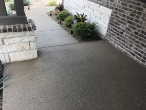 Clean concrete walkway with plants and brick walls
