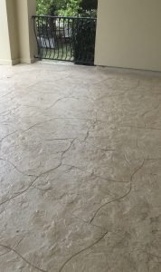 Textured concrete patio with black metal railing