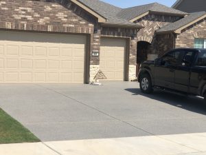 Two garage doors with parked black truck outside.