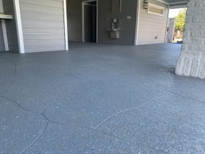 Gray textured outdoor flooring with blue specks.