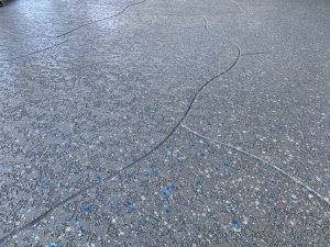 Textured gray floor with blue speckles and lines.