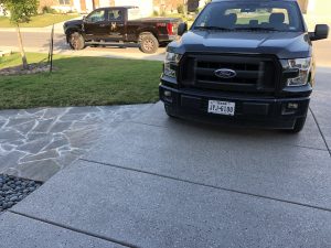 Two Ford trucks parked on a driveway.