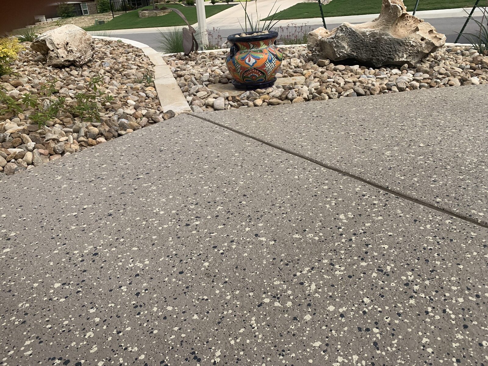 Outdoor patio with colorful pot and stones.