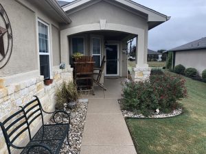 Cozy front porch with bench and plants.