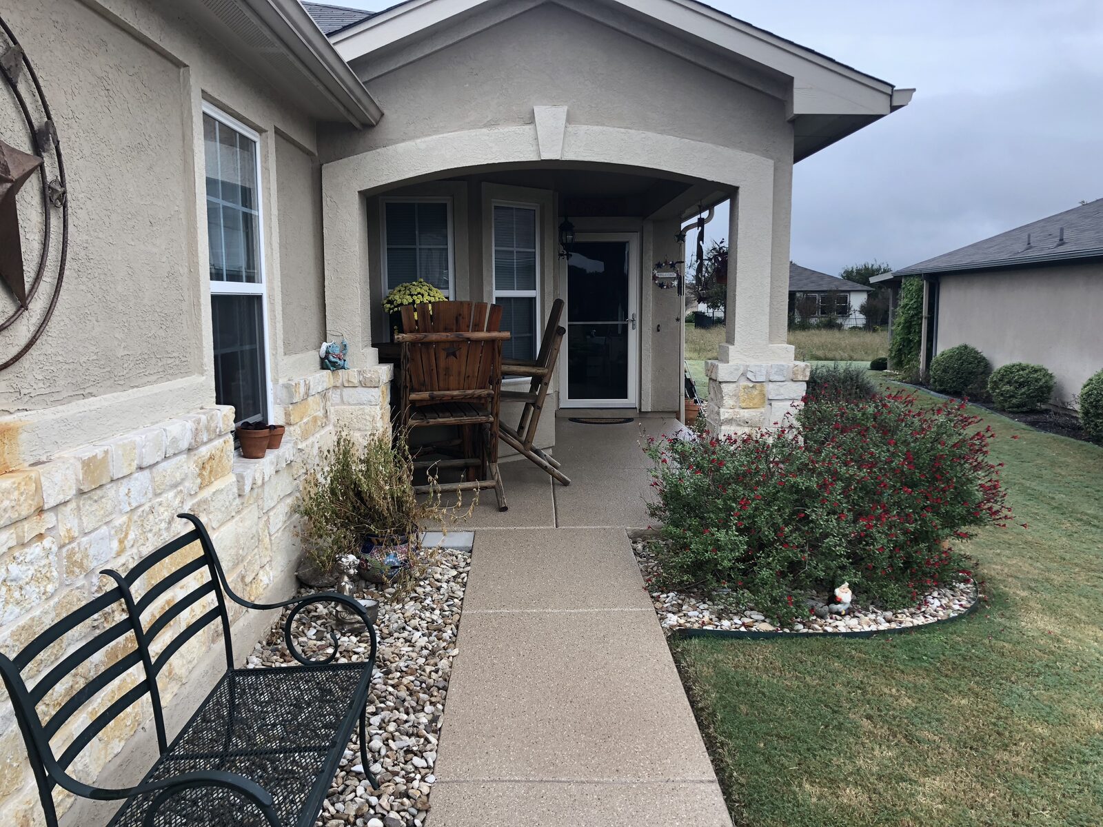 Cozy front porch with bench and plants.