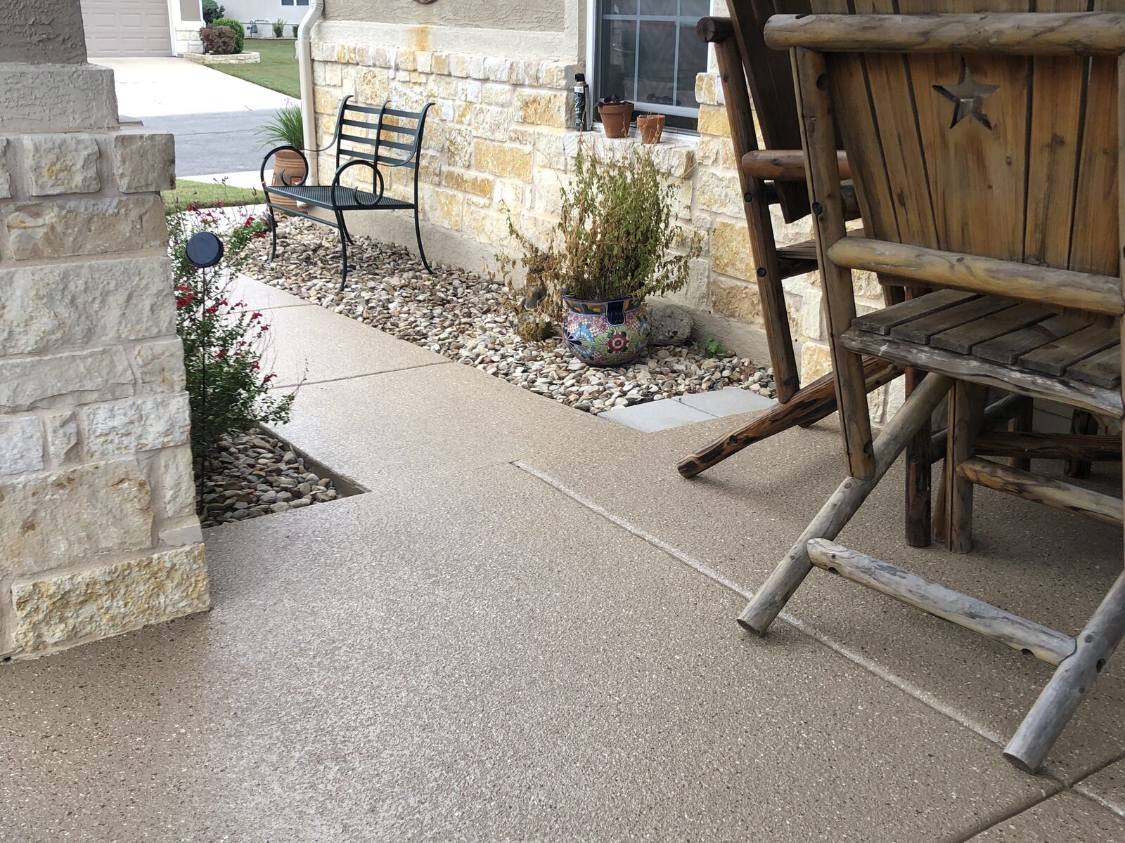 Stone patio with bench and potted plants