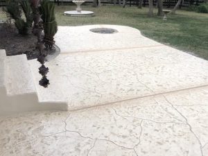 Stamped concrete patio with steps in backyard
