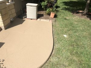 Backyard patio with grass and storage box.
