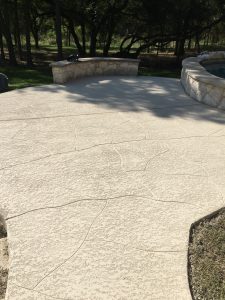 Textured stone patio with seating wall.