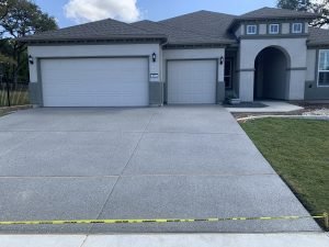 New concrete driveway with garage and lawn