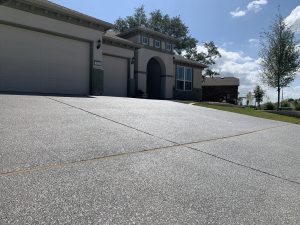 Modern house with spacious driveway and garage doors.