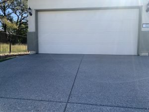 Closed white garage door, sunny driveway view.