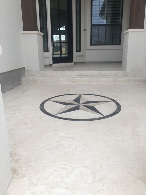 Star design on concrete porch near front door.